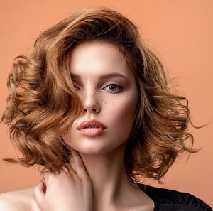 Woman with light auburn hair with a styled wispy hairstyle